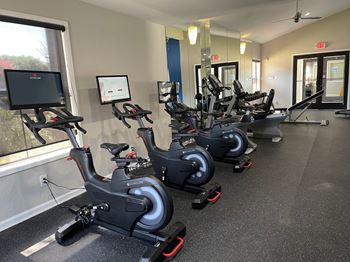 a row of exercise bikes in a gym